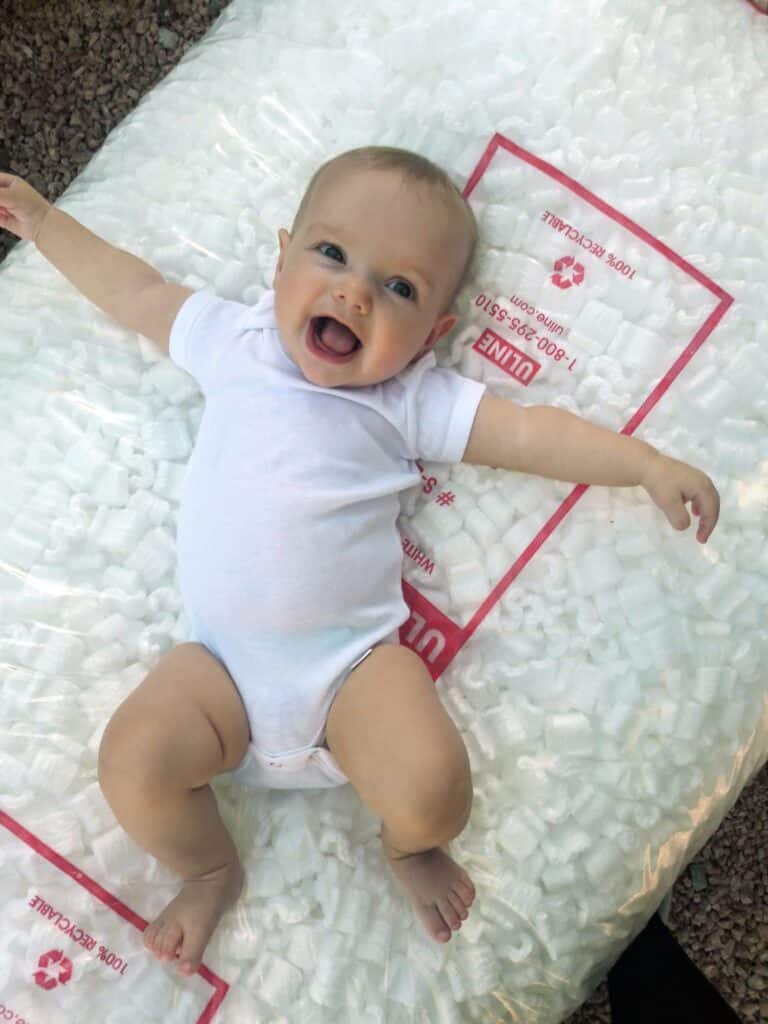 baby laying on packing peanuts